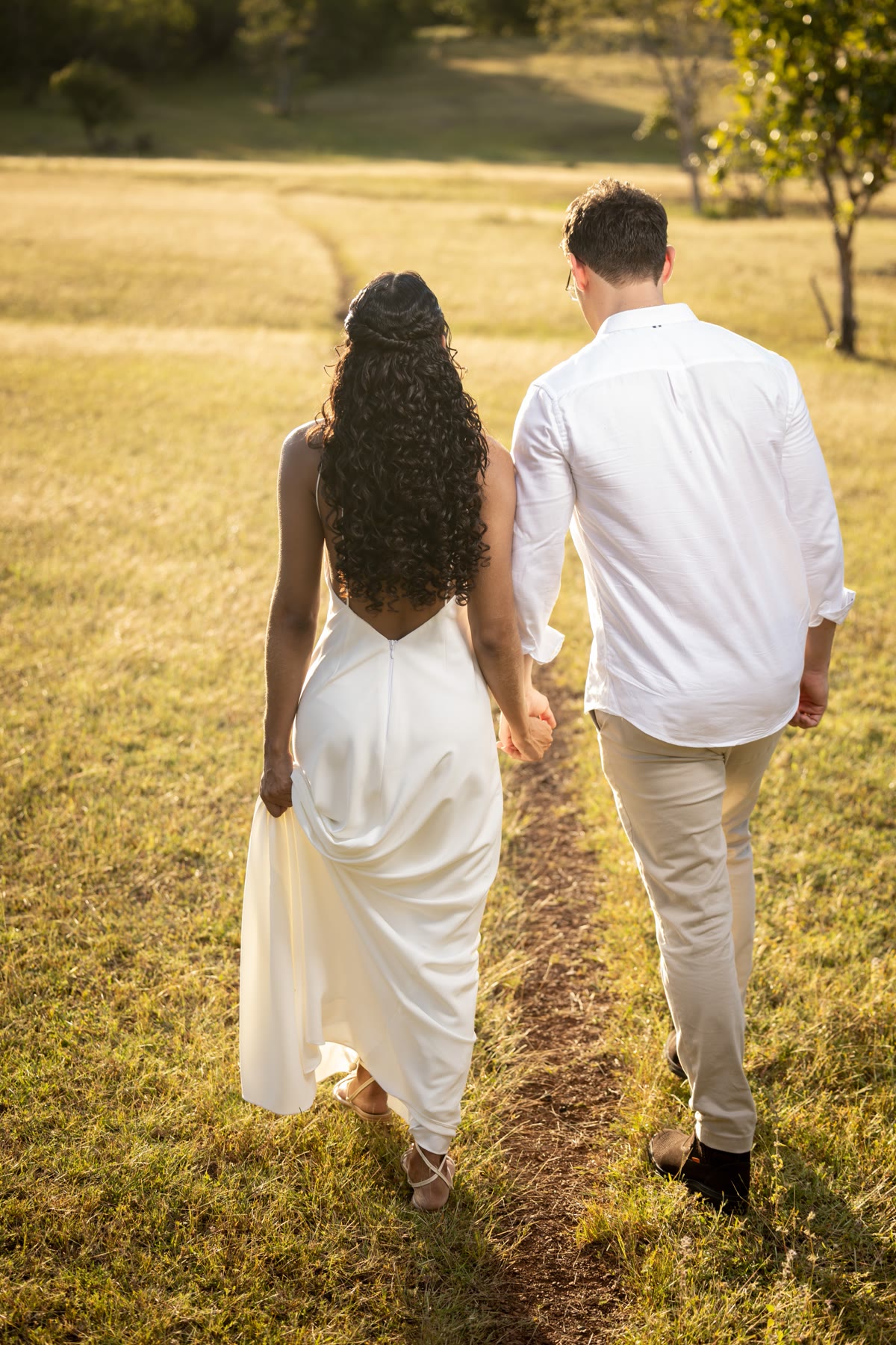 Os dois de mãos dadas caminhando pelo campo